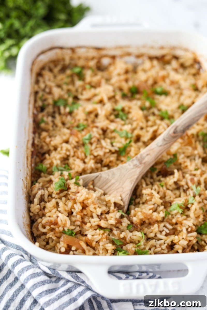 Golden Butter Rice 13 A casserole dish filled rice and garnished with parsley.