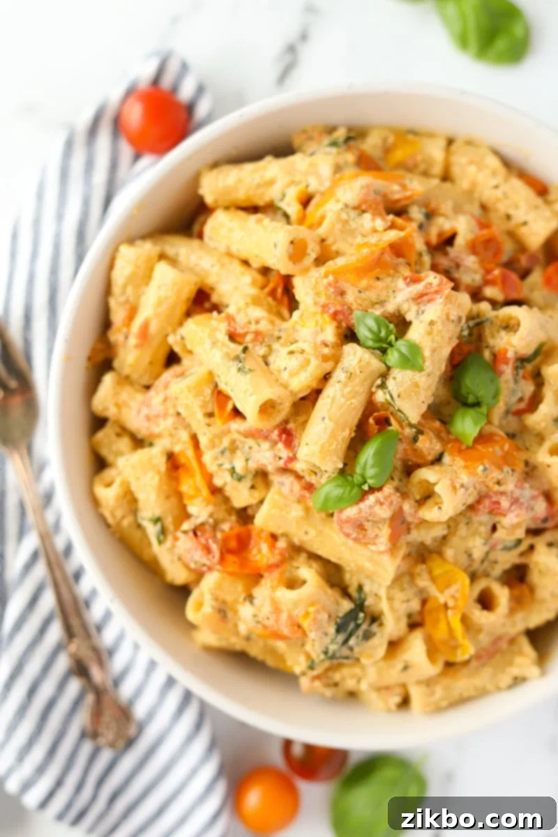 A close-up of a serving of creamy Boursin pasta in a bowl, generously topped with fresh basil, showcasing its inviting texture.