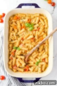 A baking dish with creamy Boursin pasta, ready to be garnished with basil.