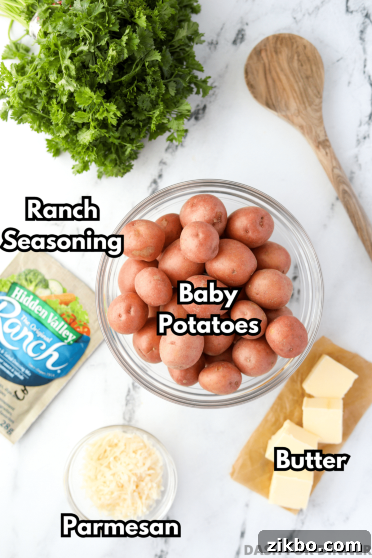 A bowl of red potatoes, some butter, parmesan, and ranch seasoning.