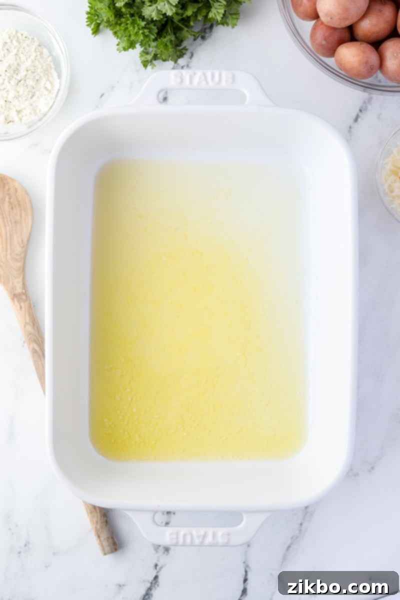 A white baking dish with melted butter.