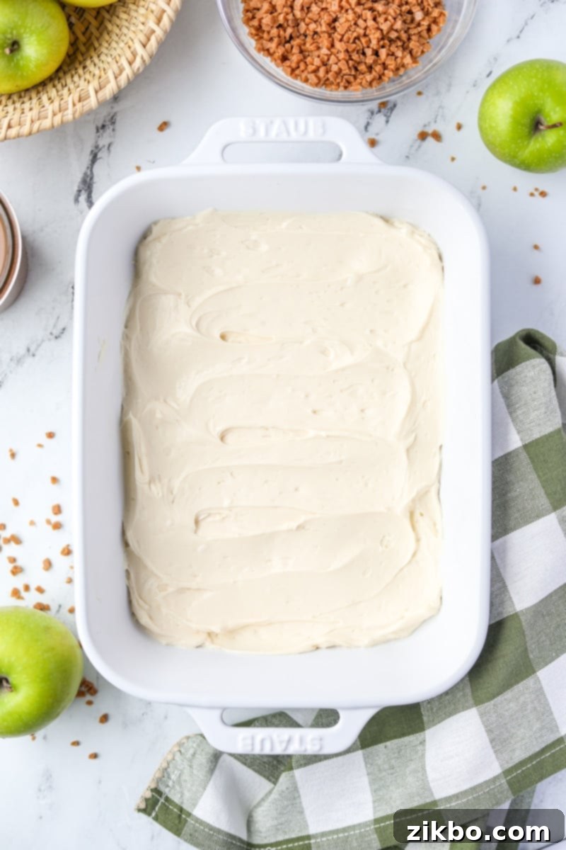 Creamy Caramel Apple Delight 6 A medium-sized baking dish with a perfectly smooth, even layer of cream cheese mixture forming the base of the dip.