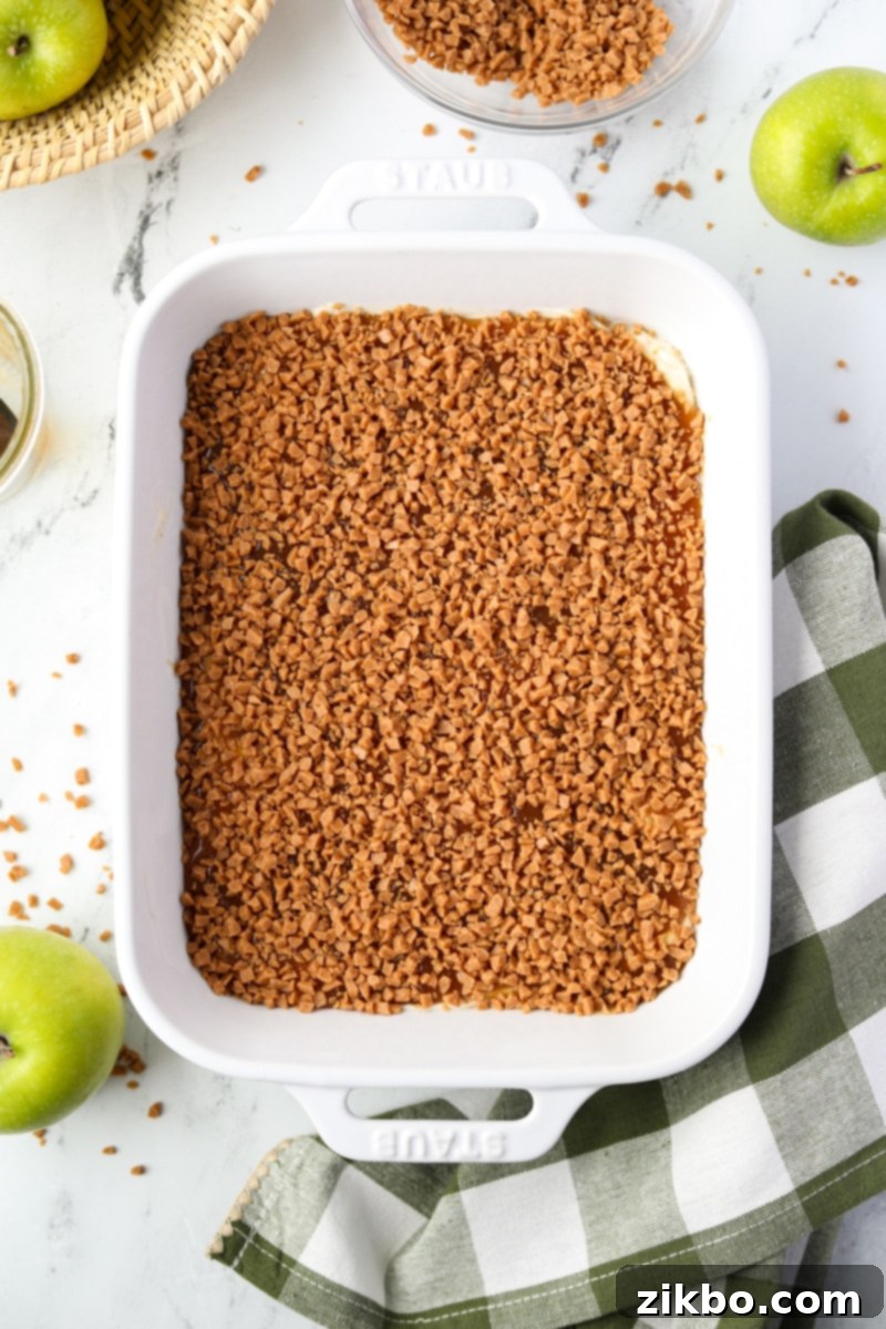 Creamy Caramel Apple Delight 9 A close-up of the completed caramel apple dip, generously covered with a glistening layer of toffee bits, ready to be served.