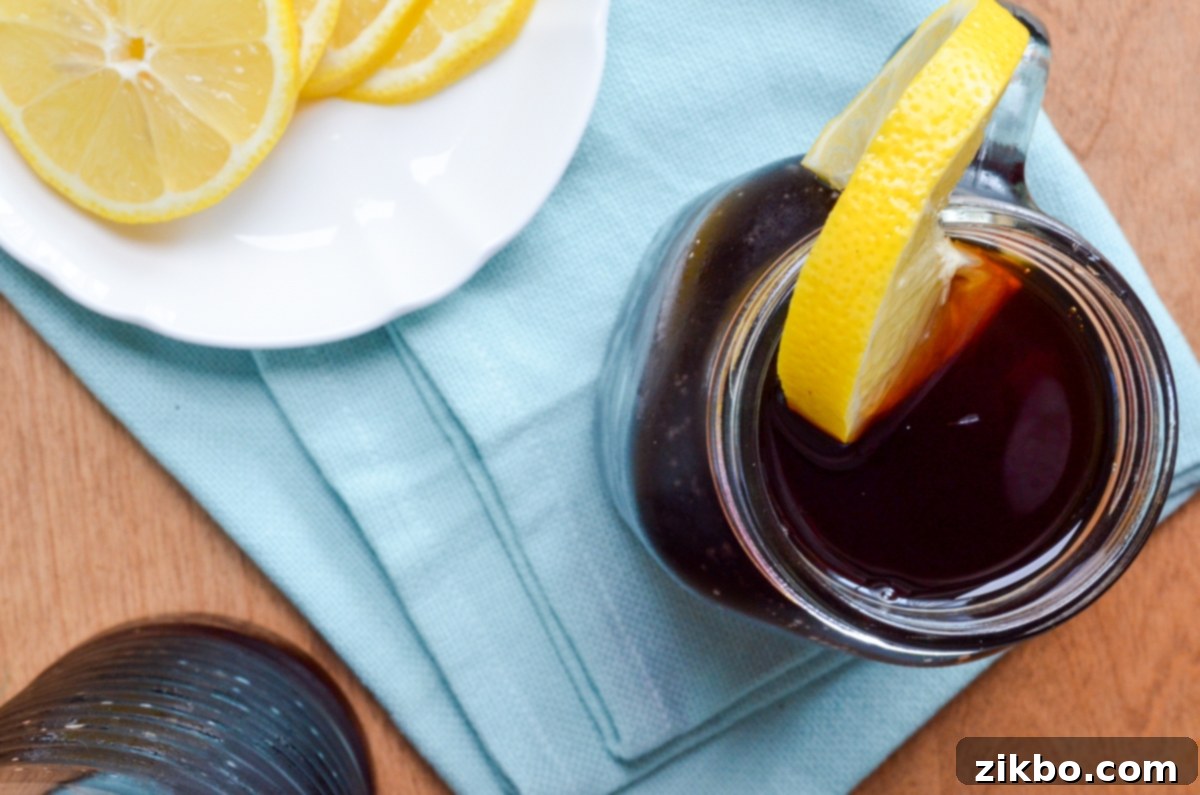 Instant Pot Iced Tea Crystal Clear and Smooth 8 A close-up of a glass of refreshing Instant Pot Iced tea with a lemon slice and condensation, emphasizing its chilled nature.