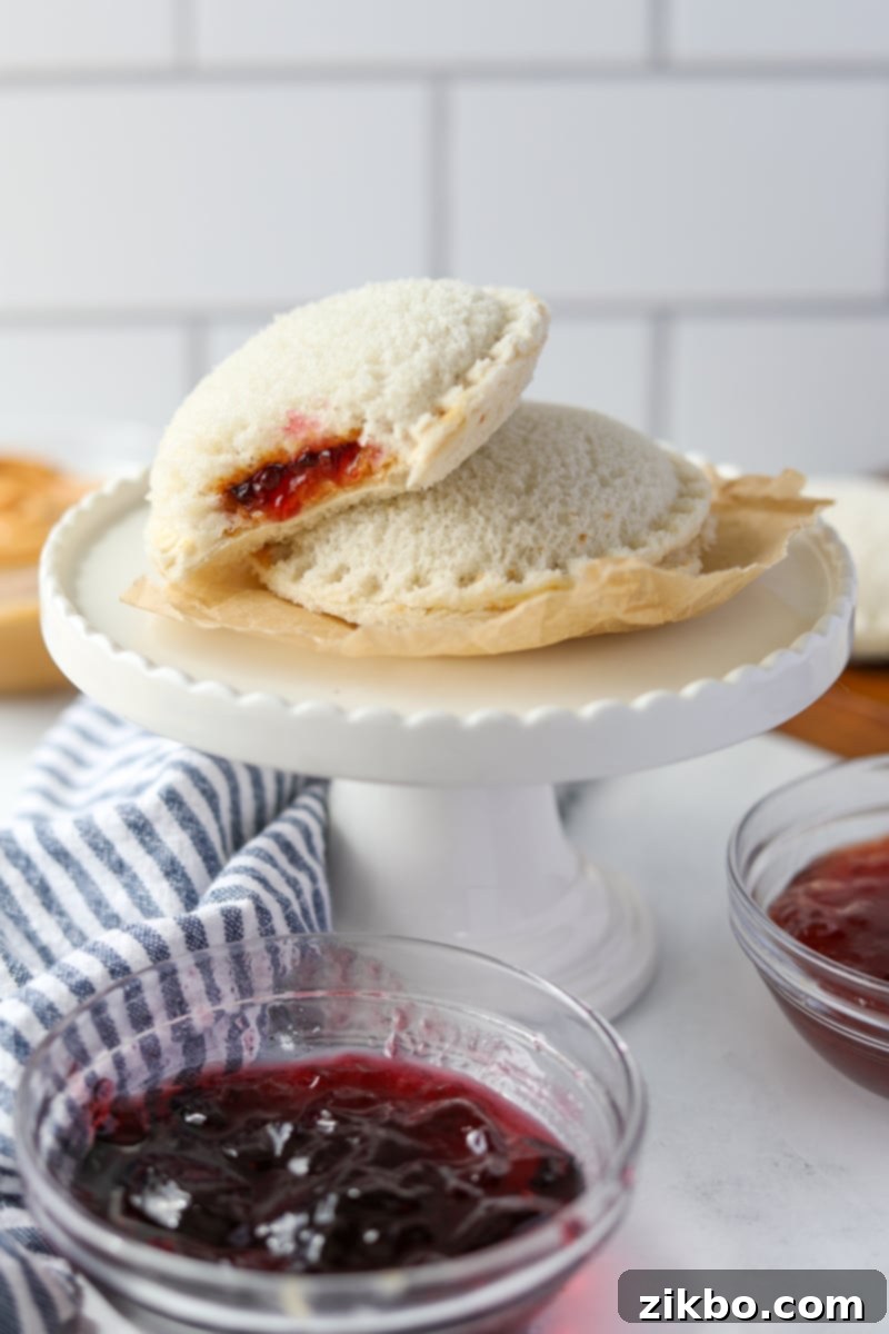 Two round sealed sandwiches on a small cake stand.