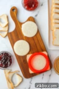 Using a round sandwich cutter to cut bread into rounds.