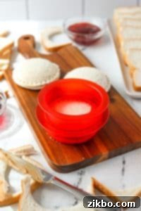 Using a sandwich sealer to press two sides of a sandwich together.