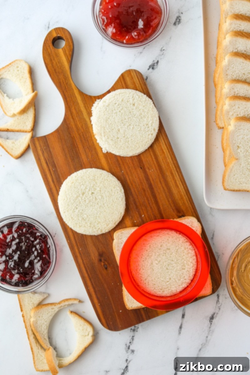 Using a round sandwich cutter to cut bread into rounds.