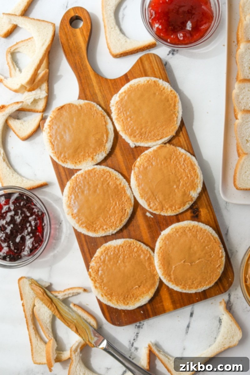 Spreading peanut butter on rounds of bread.