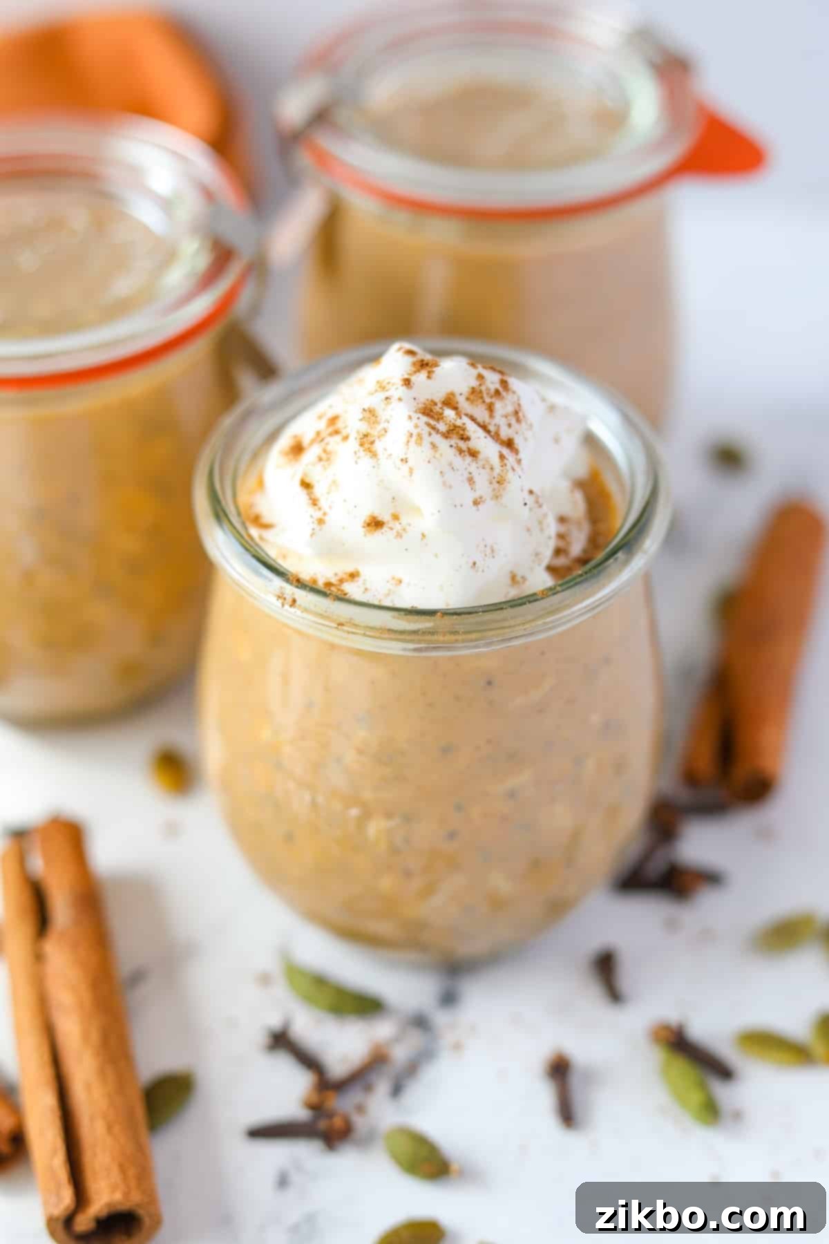A small jar of pumpkin overnight oatmeal, garnished with whipped cream.