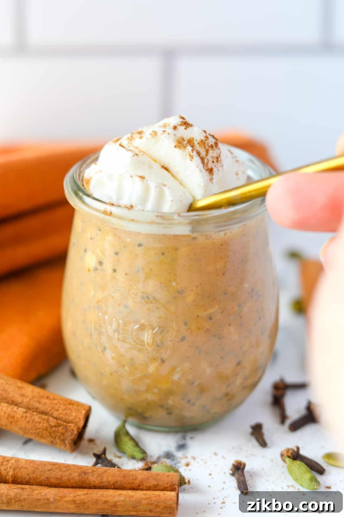 A spoon diving into a jar of overnight oats.