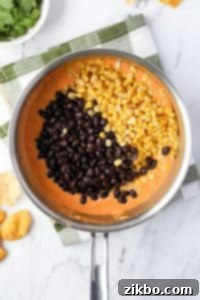 Adding beans and corn to melted Rotel dip.