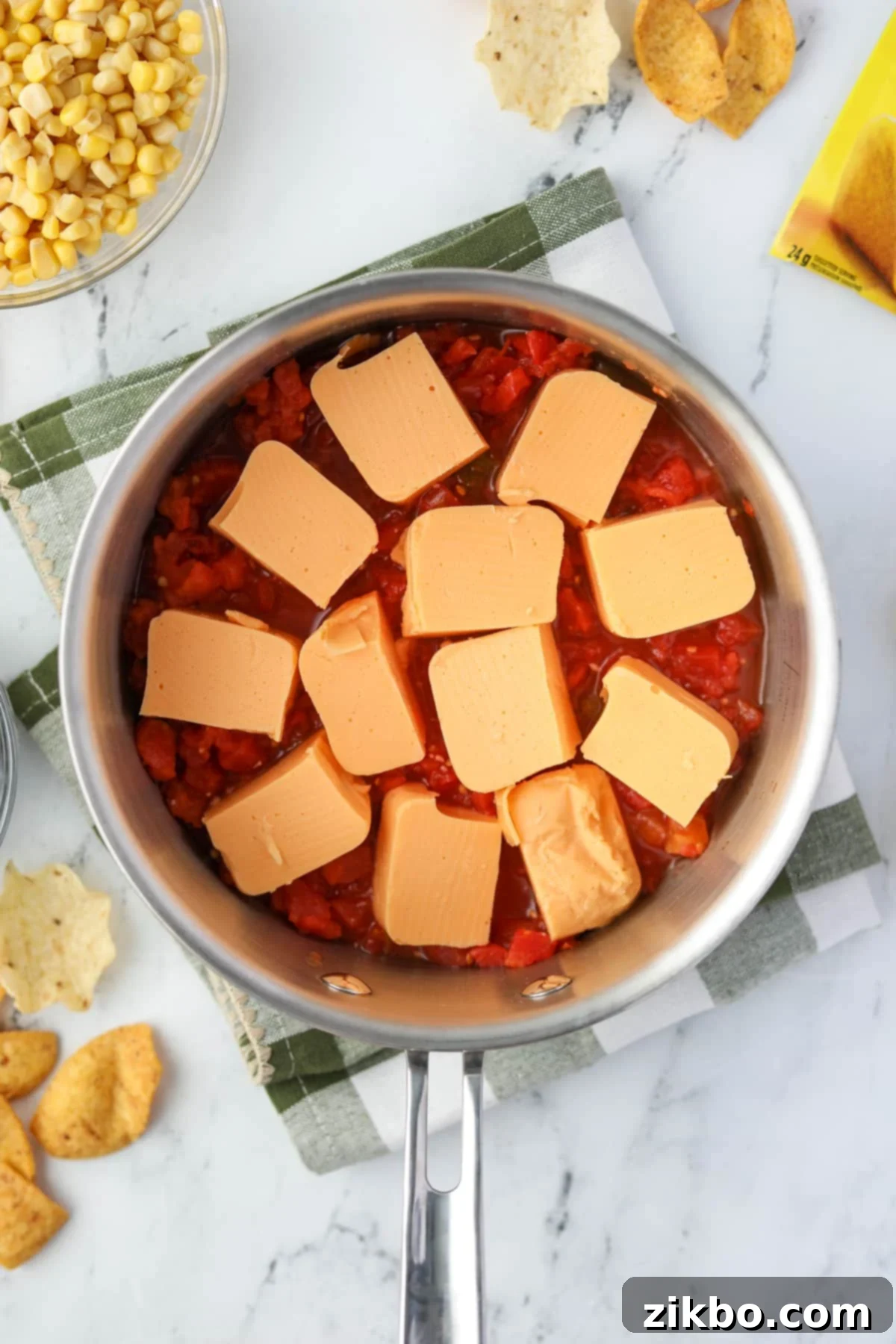 Zesty Southwest Delight 4 A saucepan filled with cubed Velveeta cheese and a can of undrained Rotel tomatoes and green chilies.