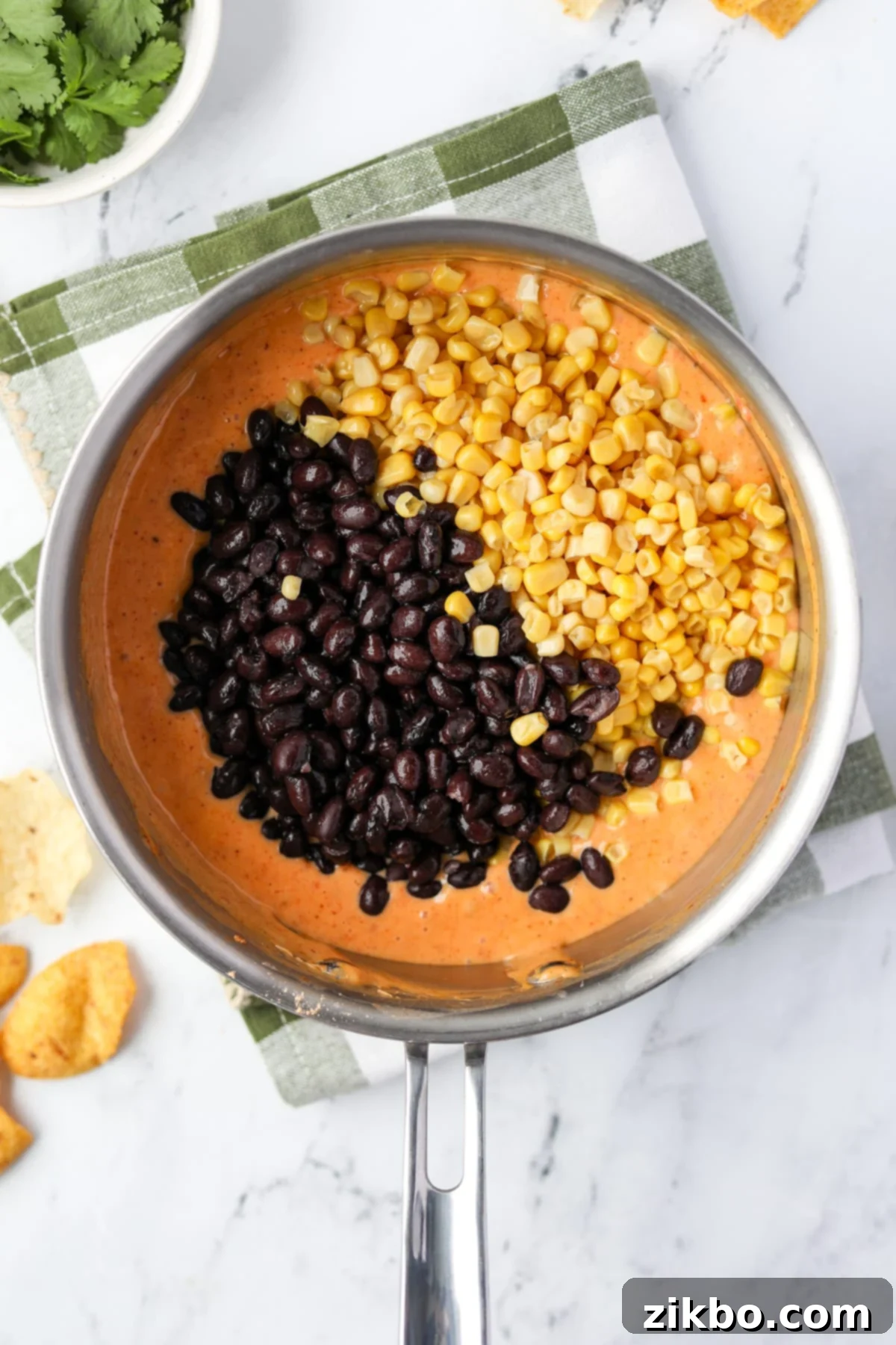 Zesty Southwest Delight 8 Adding drained black beans and corn kernels into the warm Rotel dip mixture.