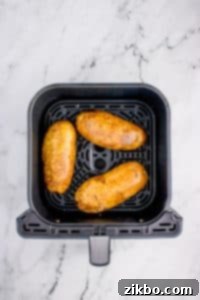An air fryer with potatoes inside.