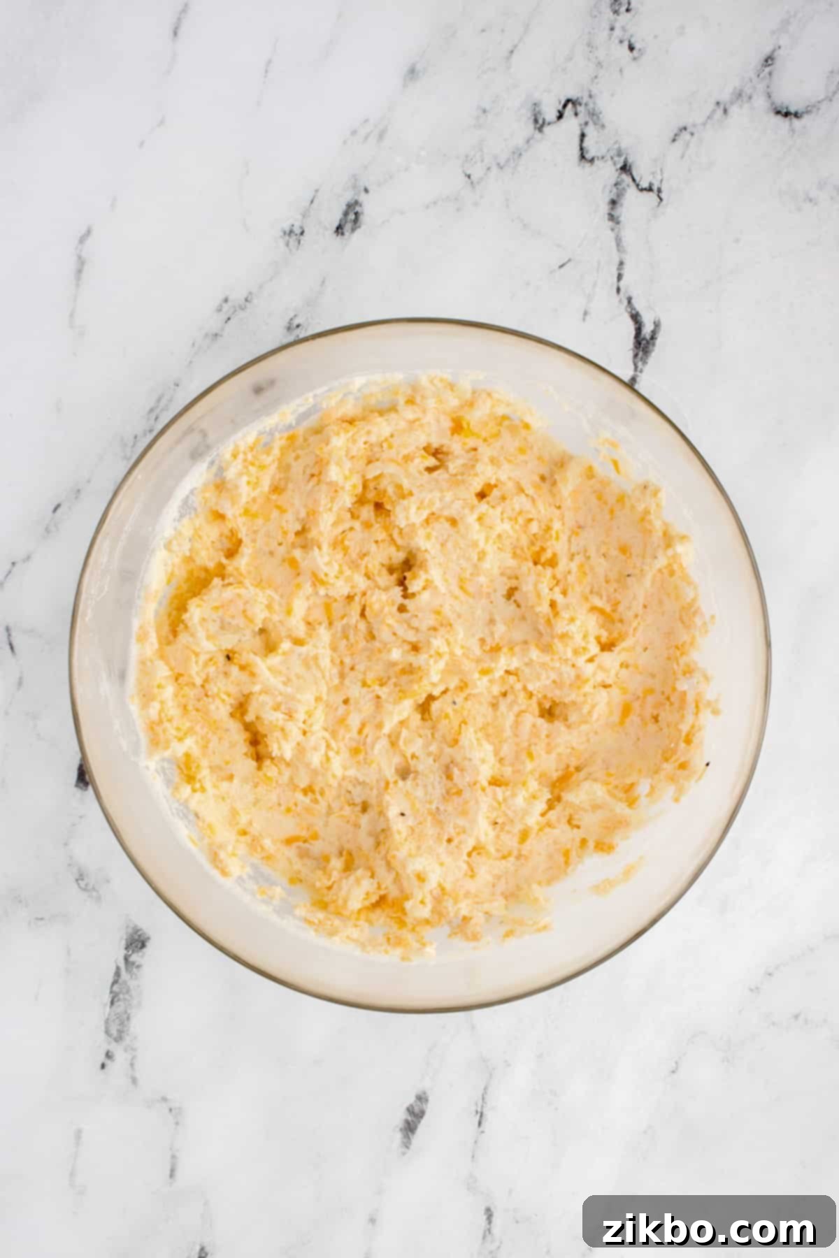Perfectly Crispy Air Fryer Twice Baked Potatoes 8 A bowl filled with a creamy, golden-yellow cheesy mashed potato mixture, perfectly blended and ready for stuffing.