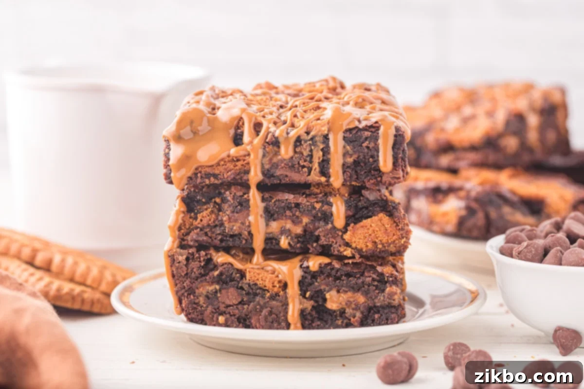 A stack of three fudgy Biscoff brownies, beautifully topped with a swirl of cookie butter, highlighting their rich, indulgent texture.