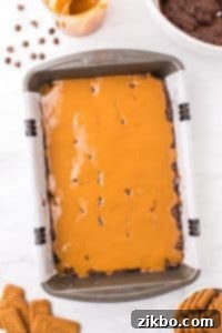 A baking pan filled with brownie batter and topped with cookie butter.