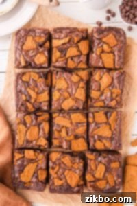 12 brownies topped with chopped Lotus Biscoff cookies.