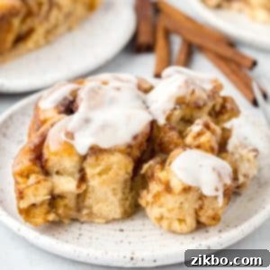 A square of cinnamon roll casserole, baked to golden perfection and topped with luscious icing.