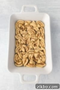 A casserole dish with cinnamon rolls sliced and fit into the dish in an even layer.
