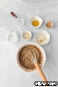 Whisking together ingredients in a bowl, with empty cups and bowls surrounding it.
