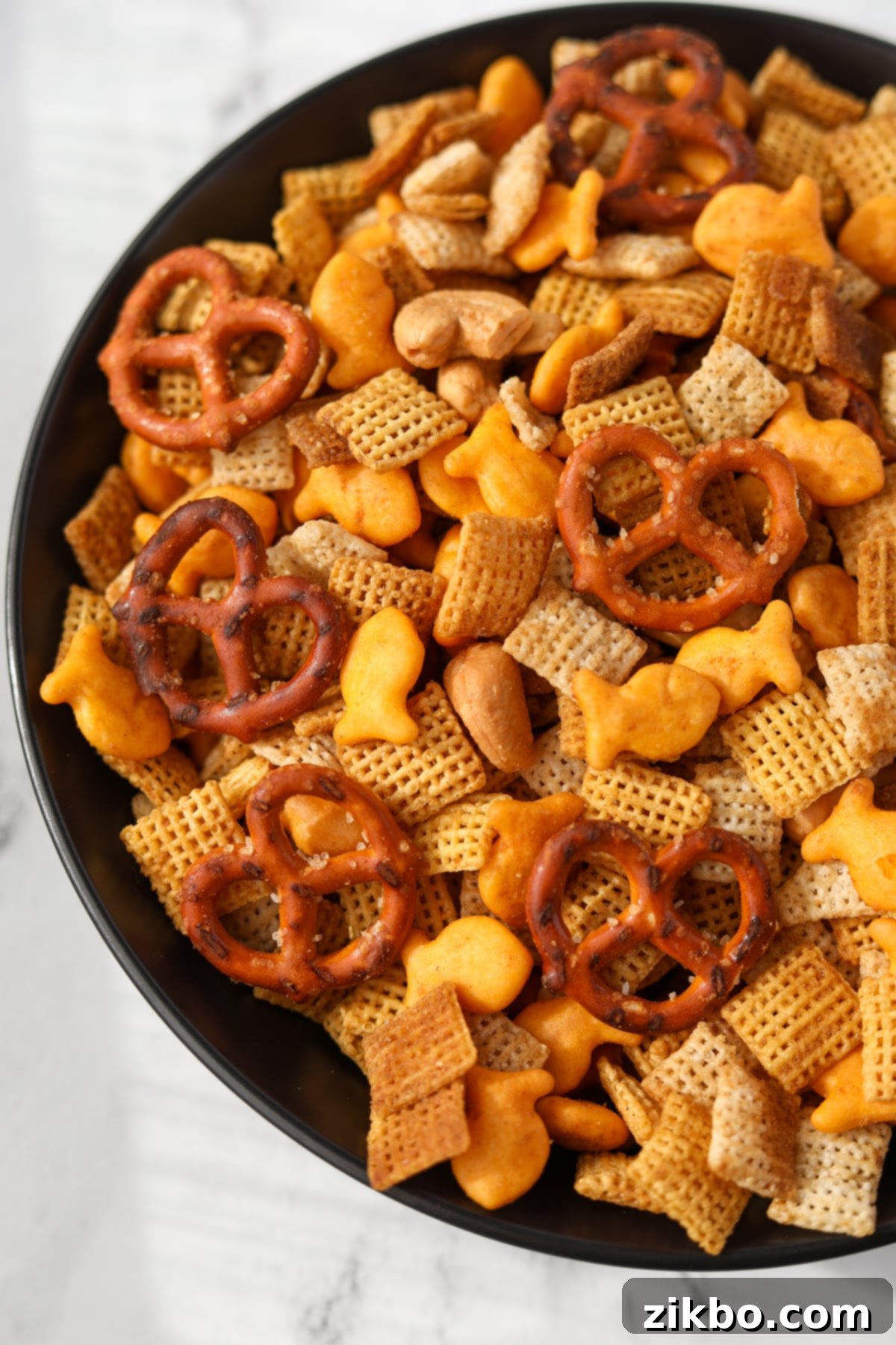 A black bowl with homemade chex mix in it.
