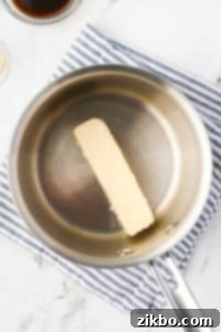 A saucepan with a stick of butter in it.