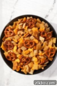 A bowl of homemade snack mix with pretzels, crackers, cereal, and nuts.