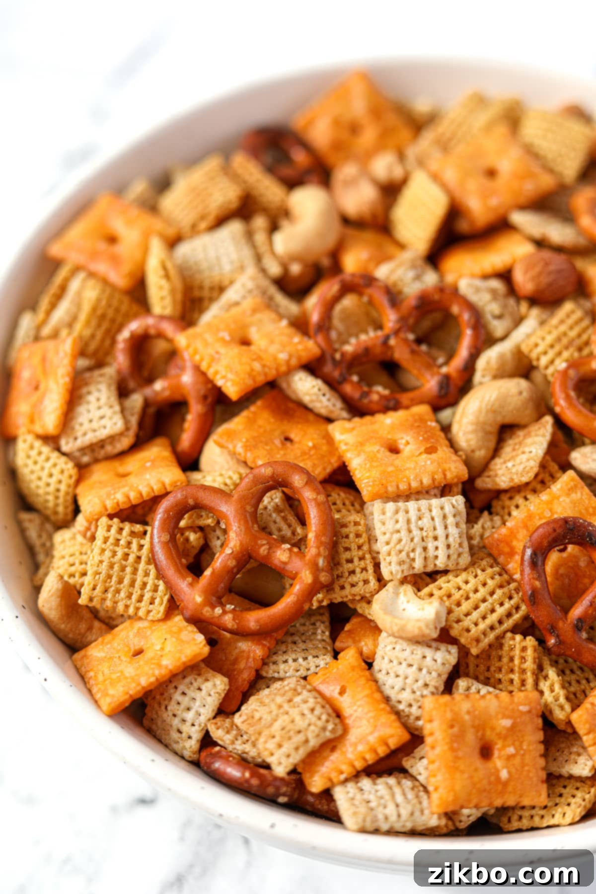 A large bowl of homemade Chex Mix with cereal, crackers, pretzels, and nuts.
