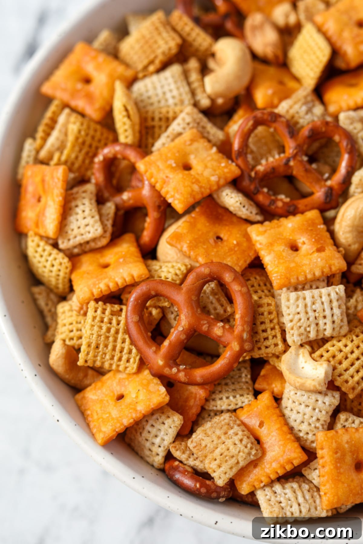 A bowl of Chex Mix with pretzels, cereal, nuts, and cheese crackers.