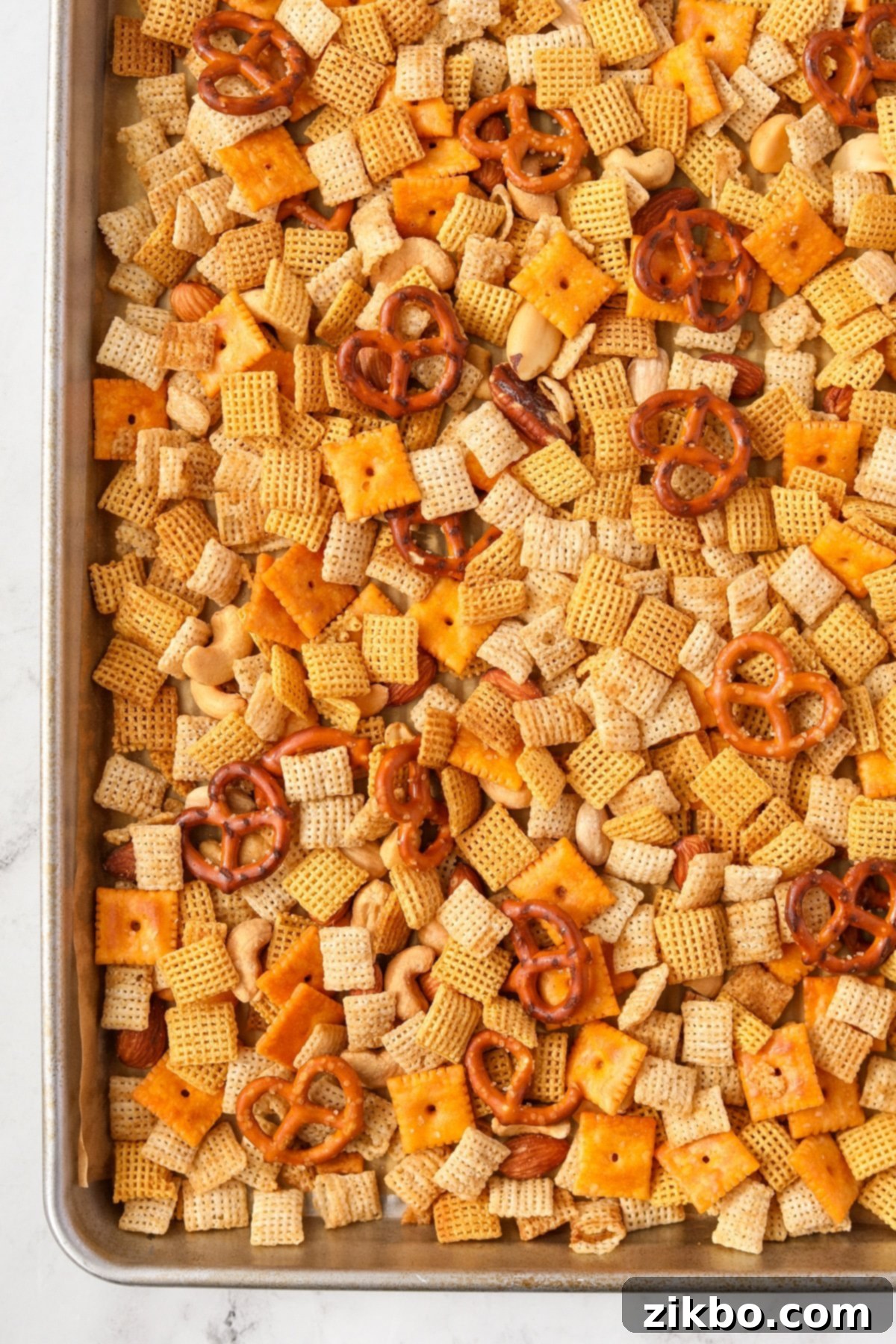 A baking sheet filled with chex mix.