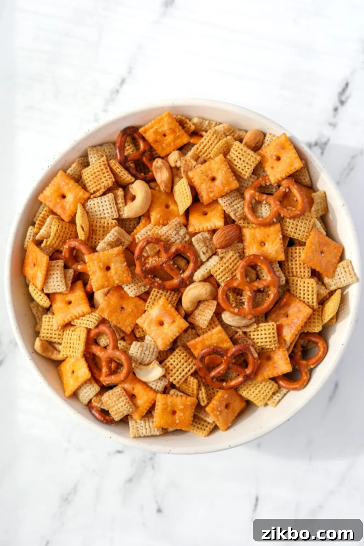 A bowl of Chex Mix on a white background.