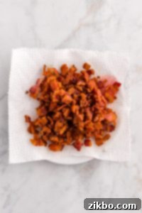 Crispy bacon draining on a paper towel.