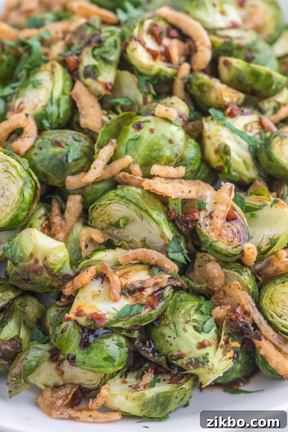 A close up of brussels sprouts that have been roasted and topped with crispy onions.