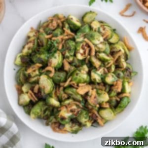 A bowl of brussels sprouts topped with crispy onions.