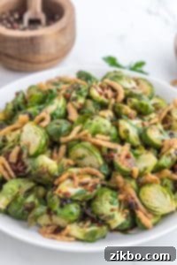 A large platter filled with roasted brussels sprouts and topped with crispy fried onions.