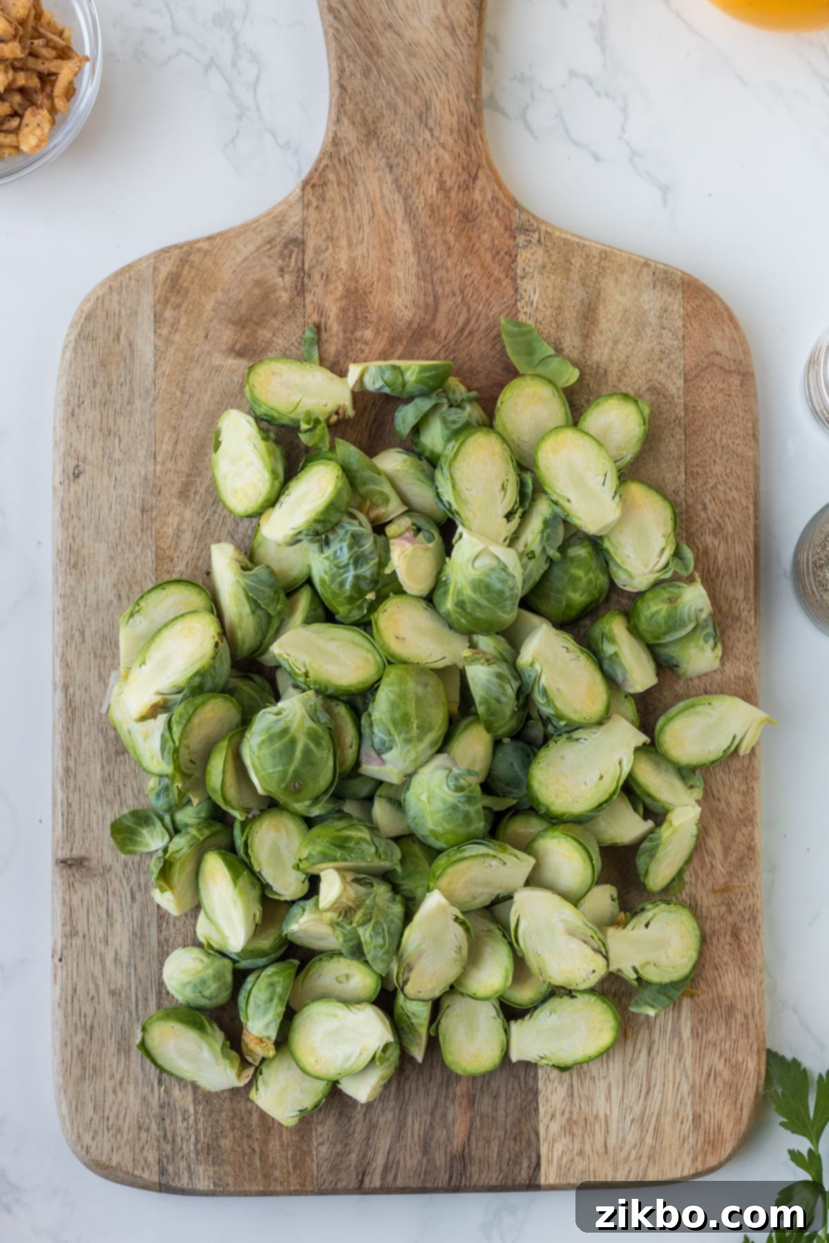 Brussel sprouts that have been cut in half laying on a cutting board.