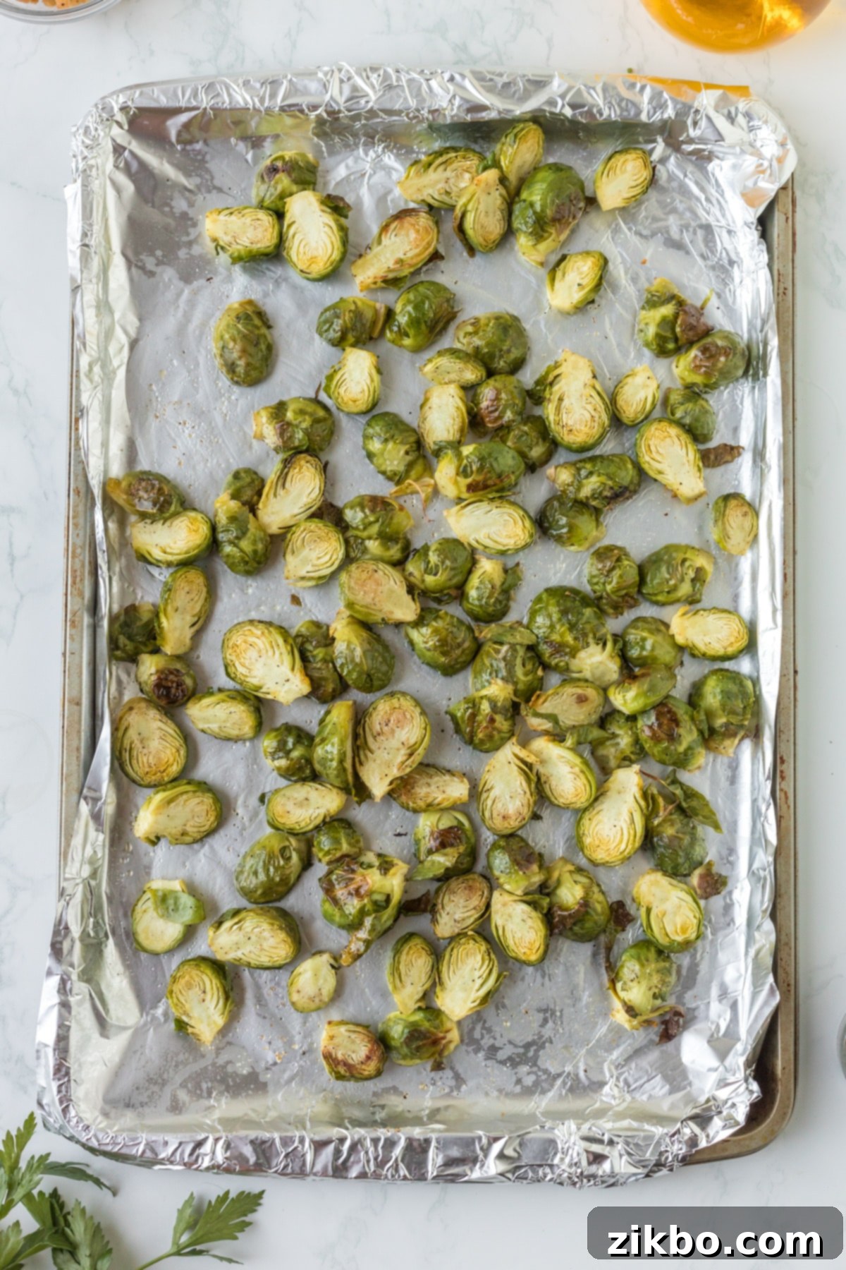 A foil-lined pan with roasted brussels sprouts.