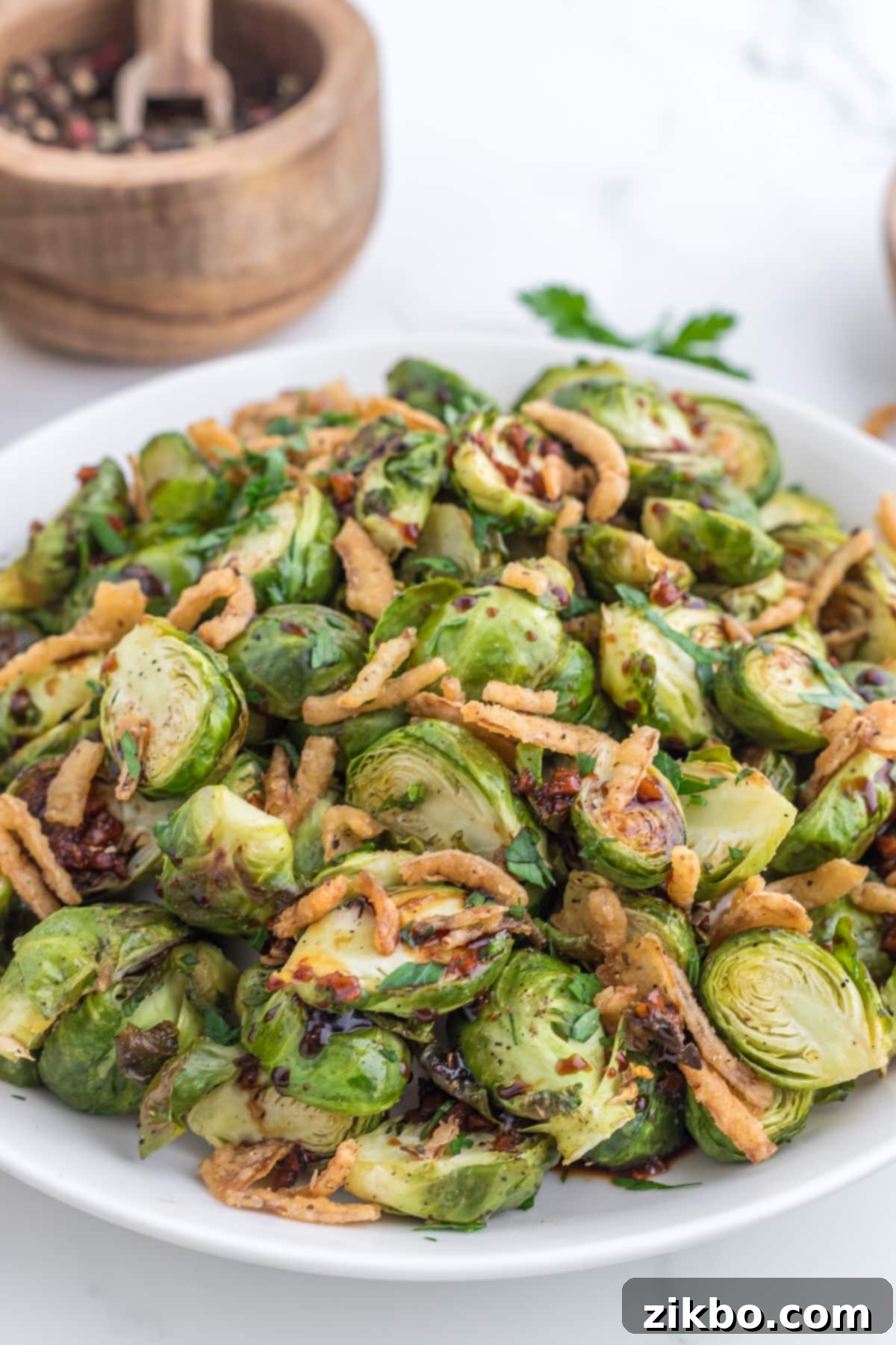 A large platter filled with roasted brussels sprouts and topped with crispy fried onions.