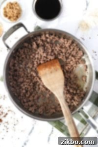 Ground beef browning in a large skillet.