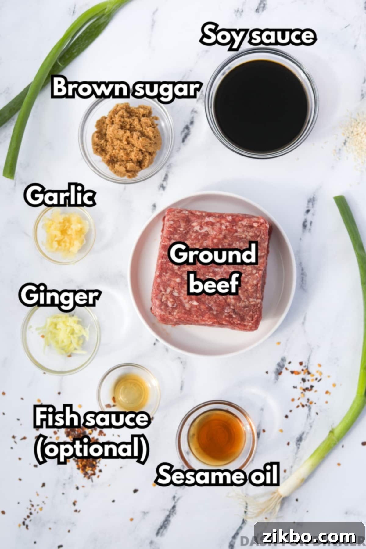A flat lay photograph showing all the ingredients for Korean ground beef, including ground beef, soy sauce, sesame oil, ginger, garlic, brown sugar, and red pepper flakes.