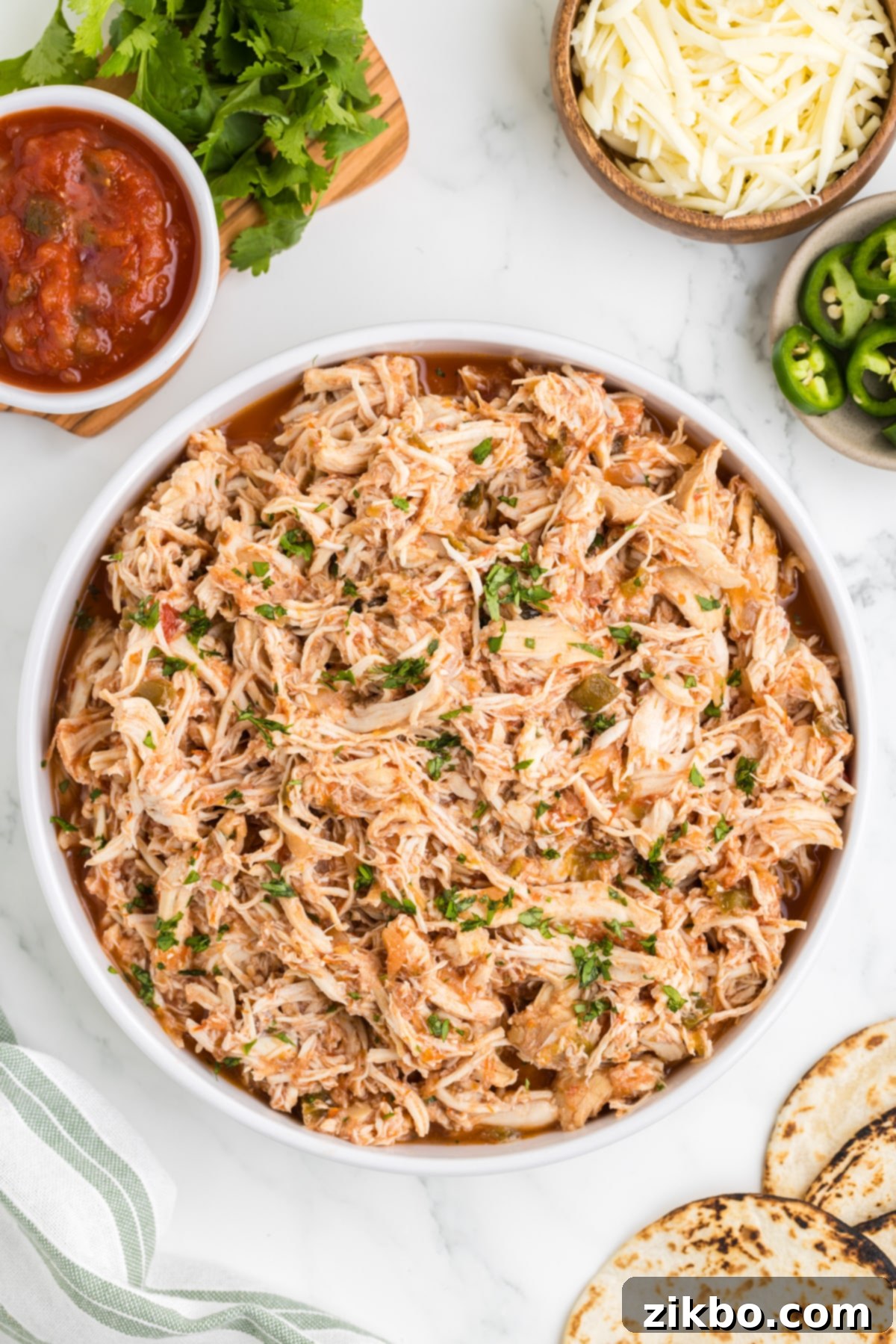 Tender Slow Cooker Salsa Chicken 11 A rustic bowl of shredded salsa chicken, beautifully garnished with fresh cilantro, ready to be enjoyed.