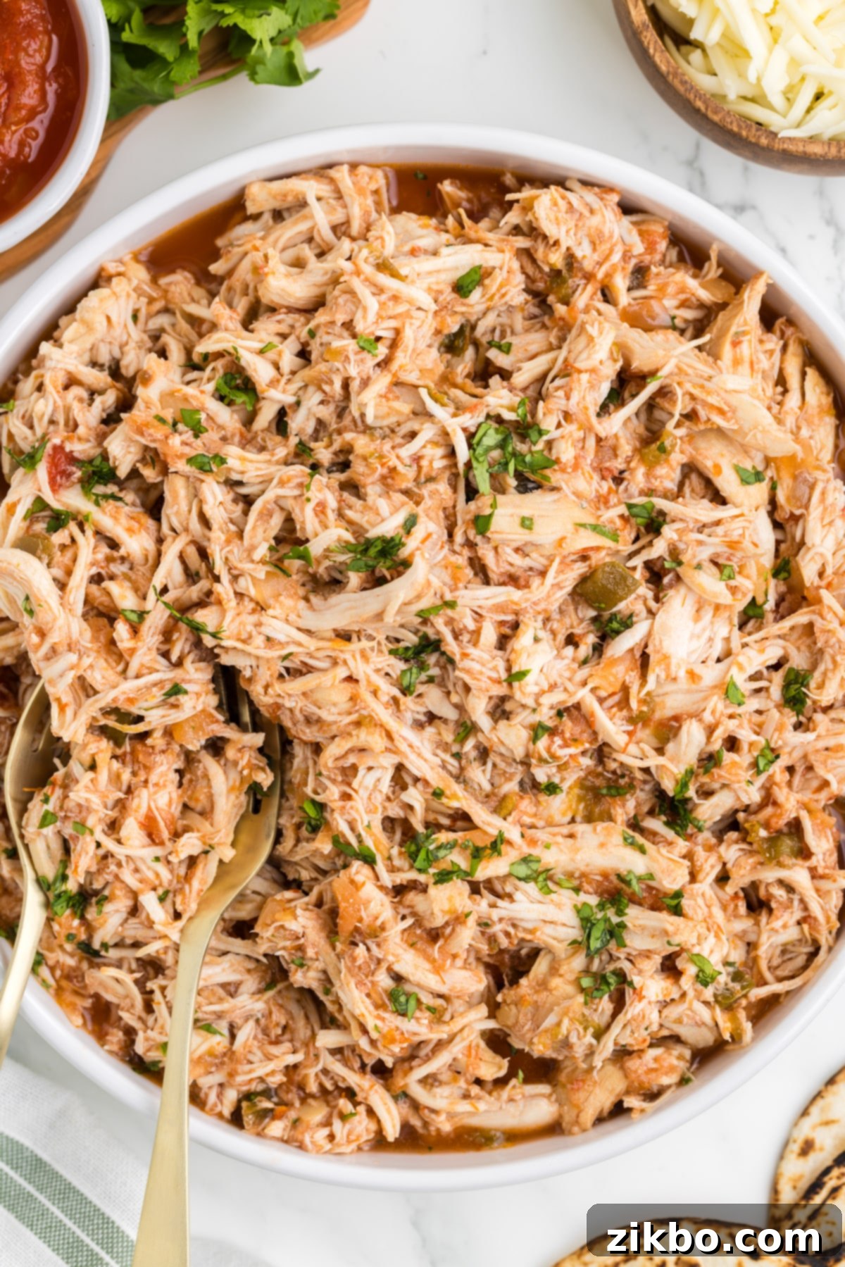 Tender Slow Cooker Salsa Chicken 13 A charming bowl filled with beautifully shredded chicken, thoroughly cooked in a rich, flavorful salsa.