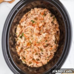 Tender Slow Cooker Salsa Chicken 15 A slow cooker filled with shredded chicken that has been cooked in salsa.