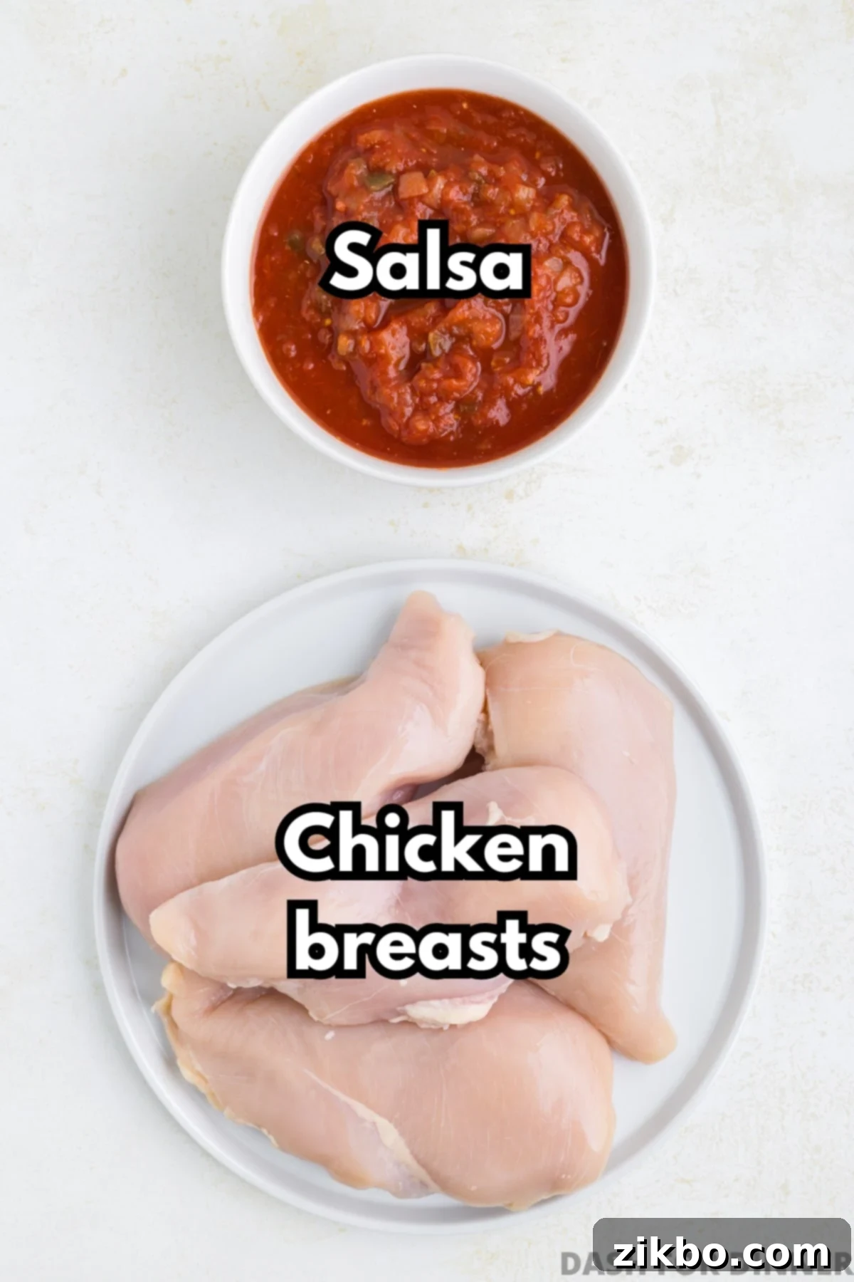 Tender Slow Cooker Salsa Chicken 3 A plate of fresh chicken breasts, with a vibrant bowl of salsa on a pristine white background, showcasing the two main ingredients.