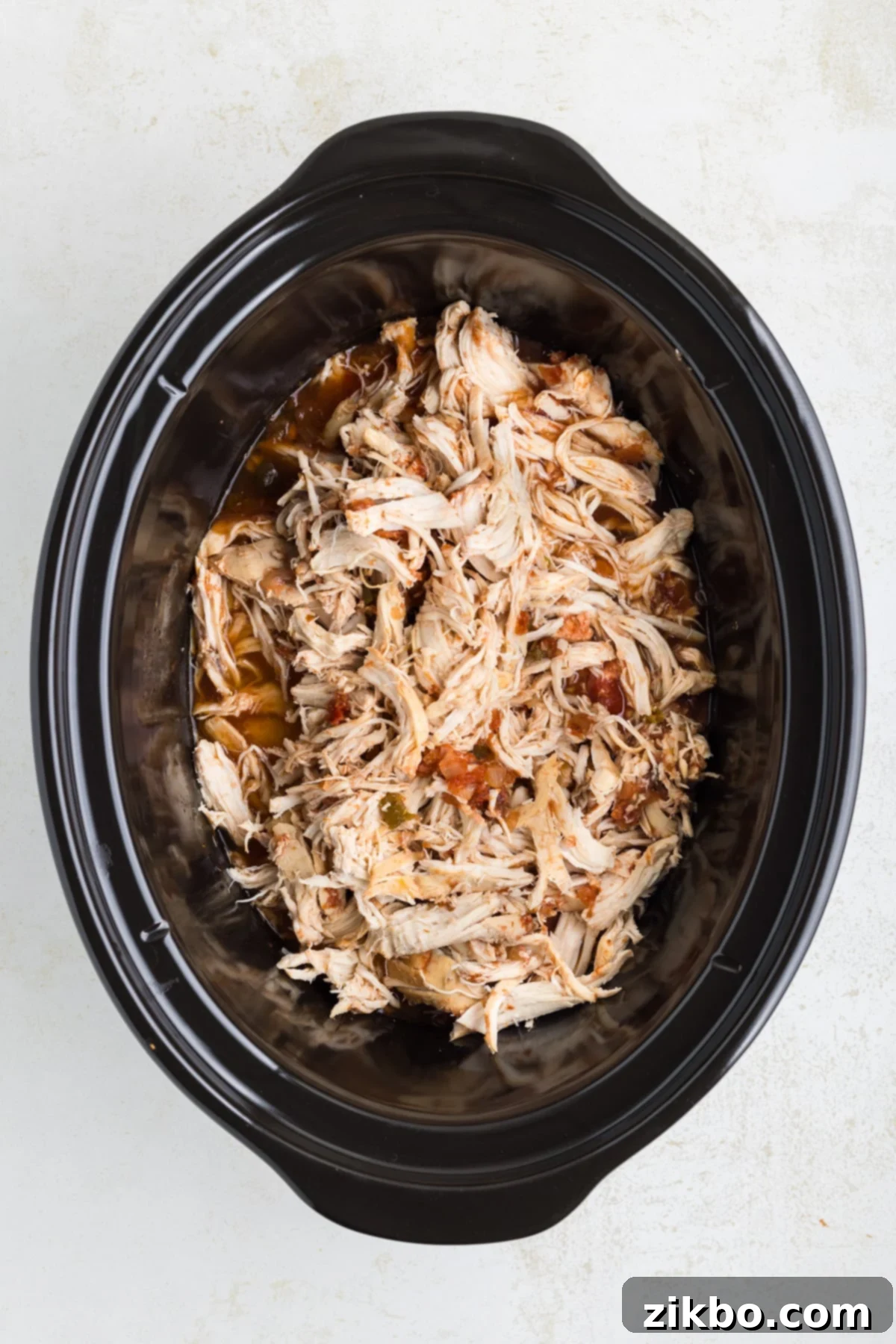 Tender Slow Cooker Salsa Chicken 7 A slow cooker filled with perfectly shredded chicken breasts, thoroughly coated in rich salsa sauce.