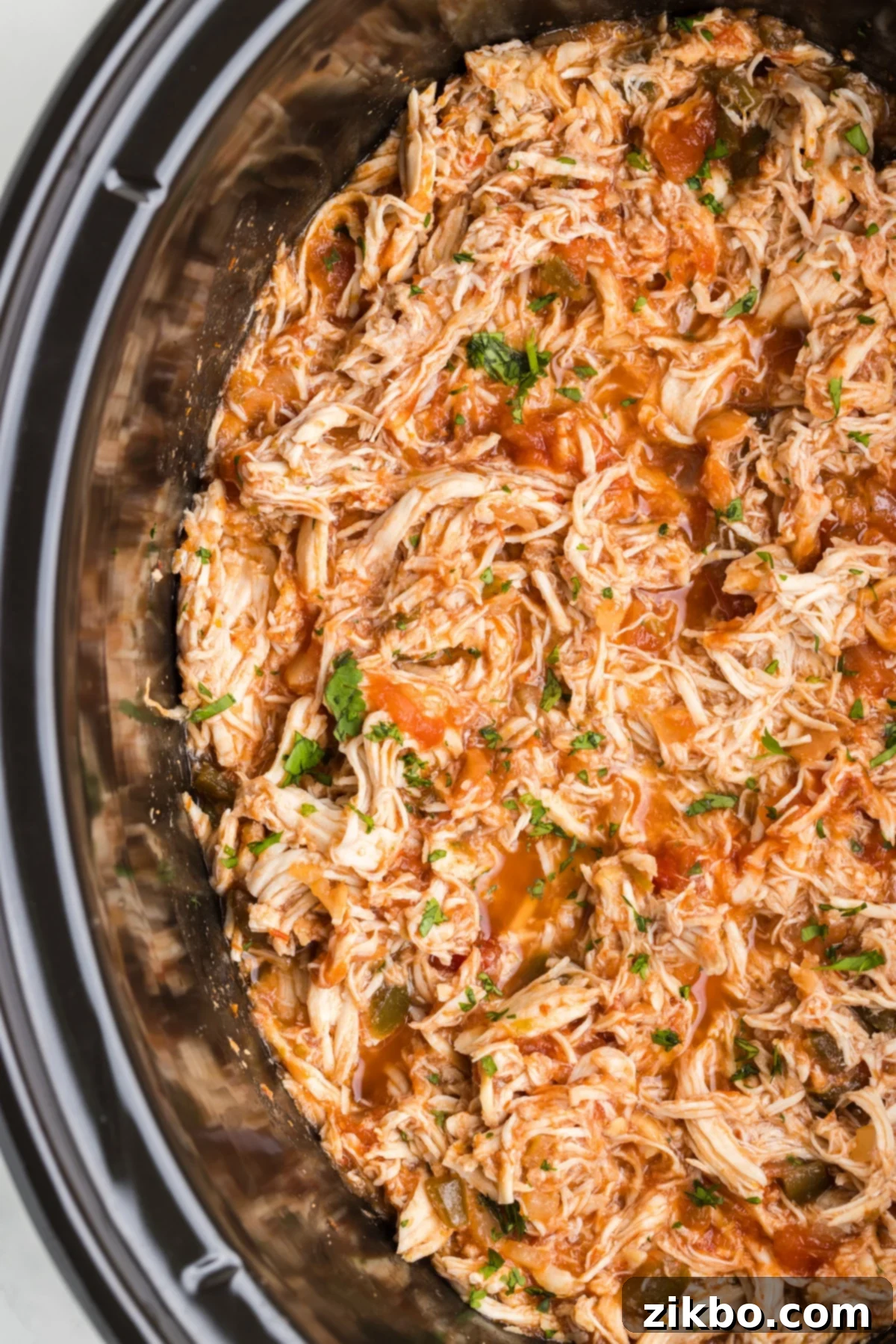 Tender Slow Cooker Salsa Chicken 8 A slow cooker filled with shredded chicken, beautifully coated in a vibrant salsa mixture, ready to be dished out.