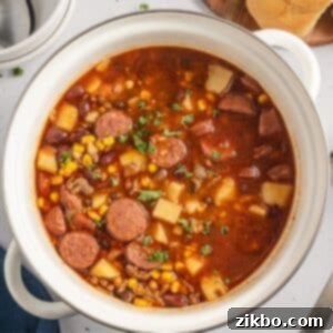A large pot filled with ground beef stew with sliced sausages.