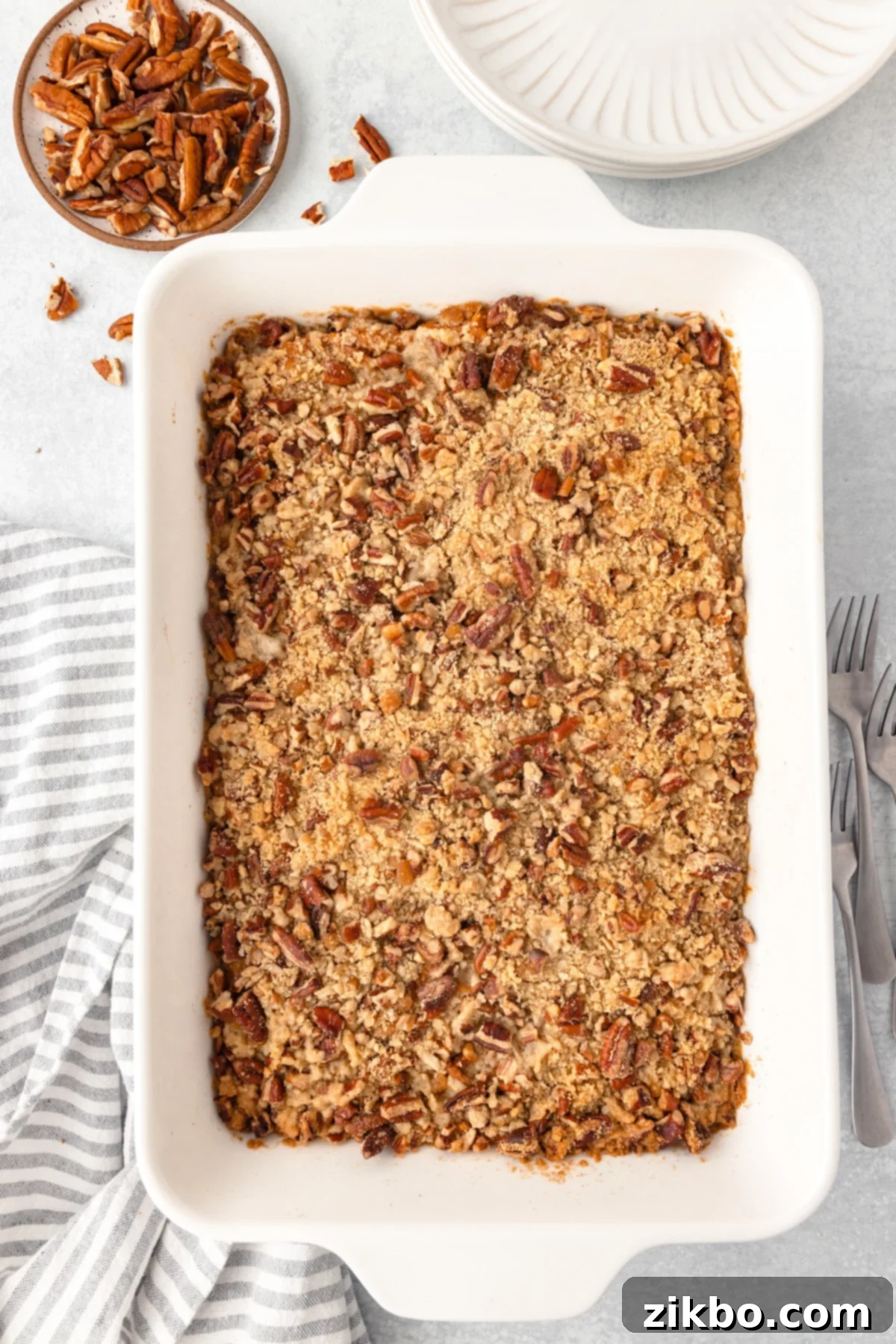 Sweet potato casserole in a large white baking dish, freshly baked and topped with perfectly toasted pecans.